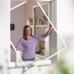 Woman demonstrating the loading frame inside a window.