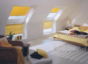 Dachfensterjalousien in einem Schlafzimmer.
