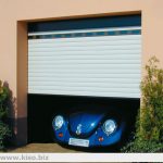 Car passing through a garage door with roller shutters.